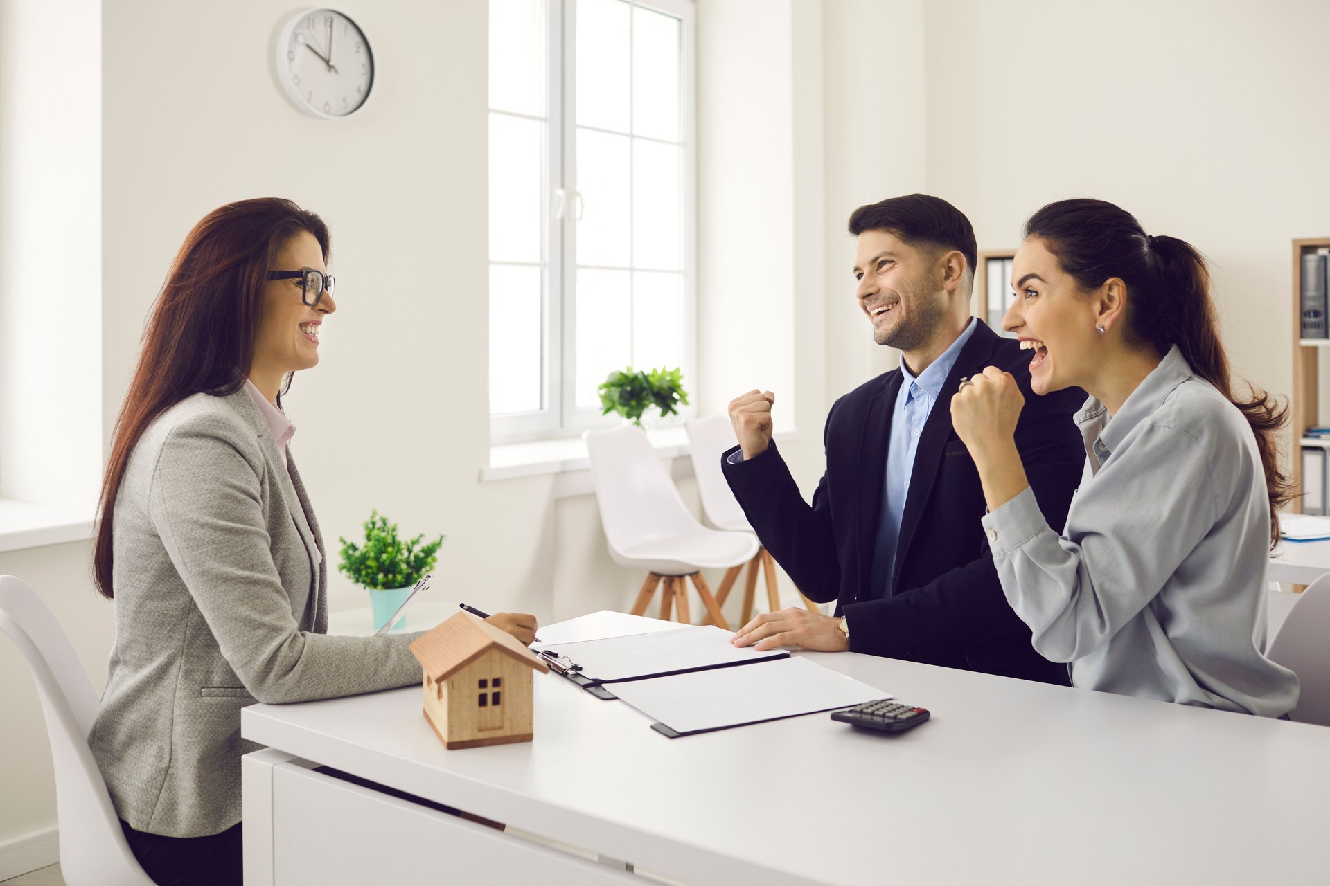 Young couple happy about getting approved for mortgage or buying new house or flat